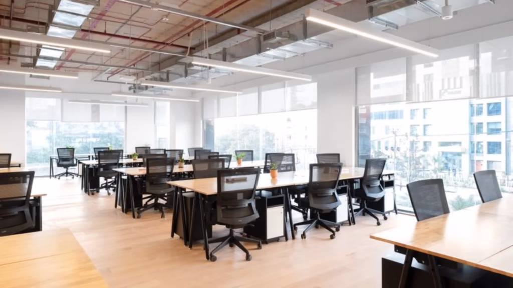 Bright, modern managed office space with open desks and ergonomic chairs, illustrating how such environments support remote and hybrid teams in Hyderabad.